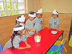 Class One pupils learning stirring pancake mix